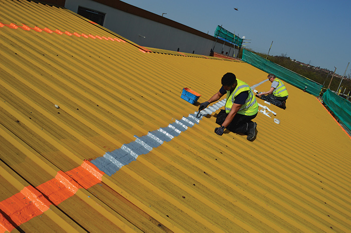 Two men working on roof, for cut edge corrosion repair